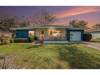 Charming single-story home showcasing a quaint porch, lush lawn, and appealing curb appeal at 908 Woodley Rd, Clearwater, FL 33764