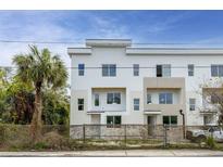 Modern townhouse featuring clean white exterior, balconies, and a nearby palm tree at 3207 N Florida Ave # 1, Tampa, FL 33603