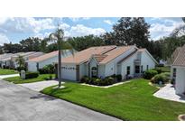 Charming single-story home featuring a well-manicured lawn, a tile roof, and an attached two-car garage at 5839 Garden Lakes Dr, Bradenton, FL 34203