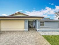 Charming single-story home with a paved driveway, light blue exterior, and well-maintained landscaping at 14113 Cook Dr, Largo, FL 33774