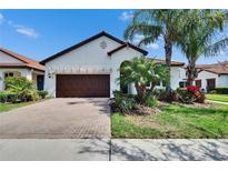Charming home with a well maintained front yard, brick driveway, and a two-car garage at 16868 Scuba Crest St, Wimauma, FL 33598