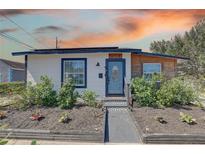 Charming single-story home featuring a garden, walkway, and blue door, set against a beautiful sunset sky at 315 40Th S St, St Petersburg, FL 33711