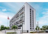 Modern condominium building with a white facade, multiple balconies and an American flag in the front yard at 3211 W Swann Ave # 502, Tampa, FL 33609