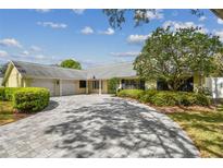 Well-maintained home featuring a winding driveway, attached garages, and mature landscaping at 4044 Priory Cir, Tampa, FL 33618