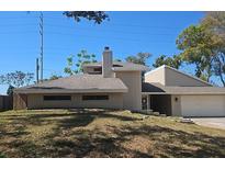 Contemporary exterior with neutral siding, chimney, and a two-car garage showcases modern architecture and curb appeal at 70 Durham Ct, Palm Harbor, FL 34683