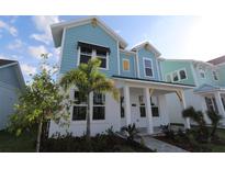 Charming two-story home featuring a colorful exterior, a welcoming front porch, and lush landscaping at 7258 Kodiak Ln, Sarasota, FL 34240