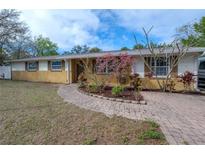 Charming single-story home with a lovely brick walkway and well-maintained landscaping at 9618 N 55Th St, Temple Terrace, FL 33617