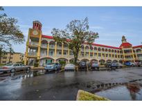Multi-story apartment building with a clock tower, parking, and arched walkways at 2430 Florentine Way # 44, Clearwater, FL 33763