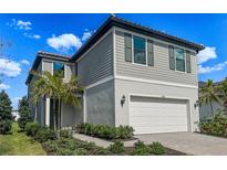 Charming two-story home with a gray exterior, two car garage, and well-manicured landscaping at 5850 Silverside Pine Ct, Bradenton, FL 34211
