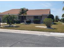 Charming single-story home boasts a terra cotta roof and meticulously maintained landscaping at 701 Baltusrol Way, Sun City Center, FL 33573