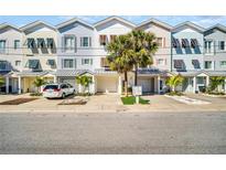 Charming multi-colored townhomes with attached garages and well-maintained landscaping offer appealing curb appeal at 130 Brightwater Dr # 5, Clearwater Beach, FL 33767