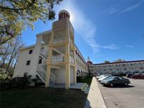 Beautiful condominium building with tower, balconies, and parking on a sunny day at 2431 Franciscan Dr # 45, Clearwater, FL 33763