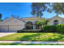 Beautiful one-story home with a well-manicured lawn and mature landscaping at 4324 Auston Way, Palm Harbor, FL 34685