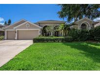 Charming home featuring a well-manicured lawn, neutral exterior, and an attached two-car garage at 4324 Auston Way, Palm Harbor, FL 34685