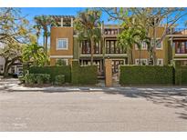 Charming multi-story townhome with lush landscaping and a private gated entrance on a sunny day at 4907 Bayshore Blvd # 115, Tampa, FL 33611