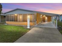 Charming single-story home featuring a screened-in porch, carport, and well-maintained lawn at 4920 Blanco Dr, Zephyrhills, FL 33541
