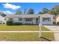 Charming one-story home featuring well-maintained landscaping, lush green grass, and bright exterior paint at 6337 S Lansdale Cir, Tampa, FL 33616