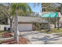 Charming single-story home with a stone-accented facade, mature landscaping, and a screened-in pool visible in the background at 12030 Steppingstone Blvd, Tampa, FL 33635