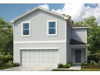 Charming two-story home with a two-car garage, grey siding, and a neatly landscaped lawn at 13325 Tropical Breeze Way, Hudson, FL 34669