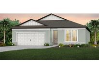 Charming single-story home featuring a two-car garage, light green exterior, and well-manicured lawn at 36812 Rio Grande Dr, Zephyrhills, FL 33540
