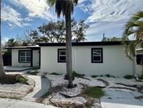 Side view of this single Gathering home, showcasing black trim around windows, minimalist landscaping, and a contemporary design at 3934 Huntington Ne St, St Petersburg, FL 33703
