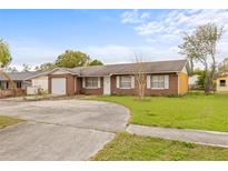 Charming brick home with a well-maintained front yard, long driveway, and attached garage at 5016 Pine St, Seffner, FL 33584