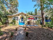 Charming single-Gathering home with a colorful exterior, blue stairs, and a cozy patio seating area at 5029 29Th S Ave, Gulfport, FL 33707