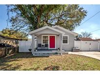 Charming single-story home with a bright pink front door and well-maintained landscaping at 6907 N 12Th St, Tampa, FL 33604