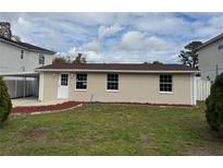 Charming single-story home with a well-manicured lawn, mulch beds and classic curb appeal at 7909 N Packwood Ave, Tampa, FL 33604
