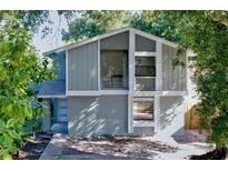 Charming two-story home with a unique architectural design and inviting curb appeal nestled among mature trees at 10408 Rosemount Dr, Tampa, FL 33624