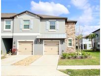 Charming townhouse with stone accents, two-car garage, and well-maintained landscaping at 14352 Editors Note St, Ruskin, FL 33573