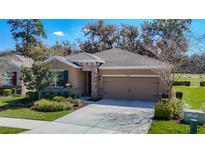 Charming single-Gathering home featuring a well-manicured lawn and stone accents, showcasing suburban curb appeal at 17749 Garsalaso Cir, Brooksville, FL 34604