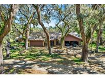 Charming single-story home with attached carport and mature trees at 2690 E Lake Trl, Tarpon Springs, FL 34688
