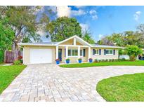Charming single-story home featuring a well-manicured lawn and brick driveway at 316 Barbara Cir, Belleair, FL 33756