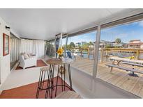 Relaxing sunroom featuring a wooden deck with waterfront views, seating, and a bright, airy atmosphere at 3515 Centavo Ct, Hernando Beach, FL 34607