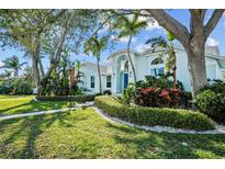 Charming two-story home with lush landscaping, mature trees, and a well-manicured lawn at 436 3Rd N Ave, Tierra Verde, FL 33715