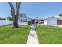 Charming single-story home with a well-manicured lawn and a welcoming red front door at 5881 31St N Ave, St Petersburg, FL 33710