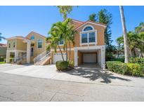 Mediterranean-style home featuring a two-car garage and a charming front yard with tropical landscaping at 18 Crescent S Pl, St Petersburg, FL 33711
