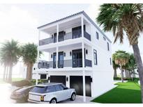 Stunning two-story home featuring double balconies, dark trim, and a spacious two-car garage at 18530 Gulf Blvd, Indian Shores, FL 33785
