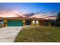 Charming single-story home with a green lawn, front yard bench, and colorful accents at 2466 Lake View Blvd, Port Charlotte, FL 33948