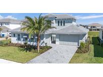 Beautiful two-story home with a paver driveway, lush landscaping, and a modern design at 33759 Ocean Spray Ln, Wesley Chapel, FL 33543