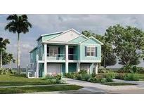 Charming coastal home featuring a two-story design, inviting porch and lush landscaping at 344 Bay St, Palm Harbor, FL 34683