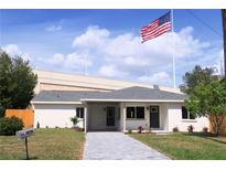 Charming single-story home featuring a manicured lawn, a gray walkway, and a prominent American flag at 4019 W Lemon St, Tampa, FL 33609