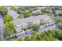 Aerial view of condo complex featuring lush landscaping, ample parking, and well-maintained buildings at 10205 Courtney Palms Blvd # 304, Tampa, FL 33619
