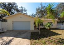 Charming single-story home featuring a well-maintained yard, attached garage, and neutral exterior paint at 12005 Wren Ct, New Port Richey, FL 34654
