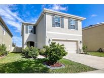 Charming two-story home with gray shutters, a well-manicured lawn, and an attached two-car garage at 16849 Trite Bend St, Wimauma, FL 33598