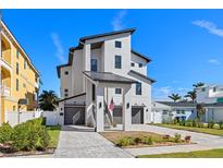 Modern three-story home featuring dual garages, eye-catching architectural details, and a paved driveway at 1843 Bayou Grande Ne Blvd, St Petersburg, FL 33703