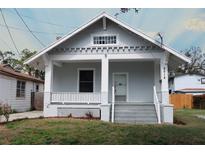 Charming bungalow-style home features a welcoming front porch and a classic architectural design with a clean, neutral color palette at 2018 Elmwood Ave, Tampa, FL 33605