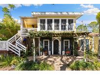 Charming two-story home with a brick patio, lush greenery, and a welcoming pergola-covered entrance at 235 1/2 17Th Ave Se Se Ave, St Petersburg, FL 33701