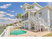 Beautiful waterfront home featuring a private pool and multi-story screened porch, perfect for outdoor enjoyment at 3415 Croaker Dr, Hernando Beach, FL 34607